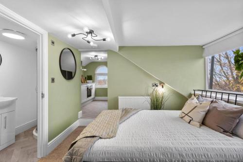 a bedroom with green walls and a large bed at Birkenhead Aparthotel in Rock Ferry