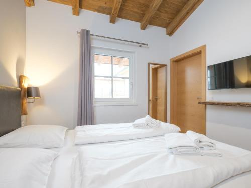 two white beds in a room with a tv at Luxury Tauern Suite Walchen Kaprun 8 in Angerberg