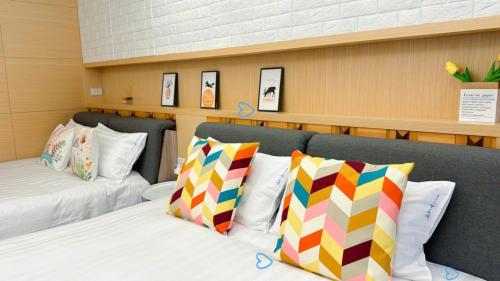 a room with two beds with colorful pillows at Hi House in Toucheng