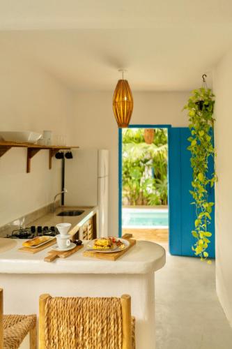 a kitchen with a table with a plate of food on it at Villa Joá - Casa no Quadrado in Trancoso
