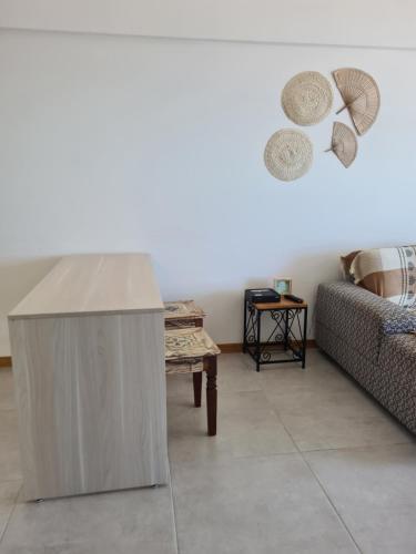 uma sala de estar com um sofá e uma mesa em Apartamento frente mar praia do flamengo em Salvador