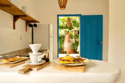 una cucina con tavolo e piatto di cibo di Villa Joá - Casa no Quadrado a Trancoso