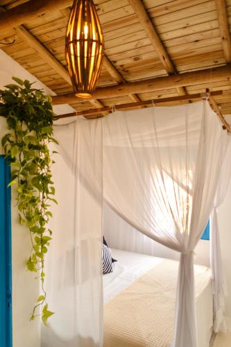 1 dormitorio con cama con dosel y columpio en Villa Joá - Casa en Trancoso