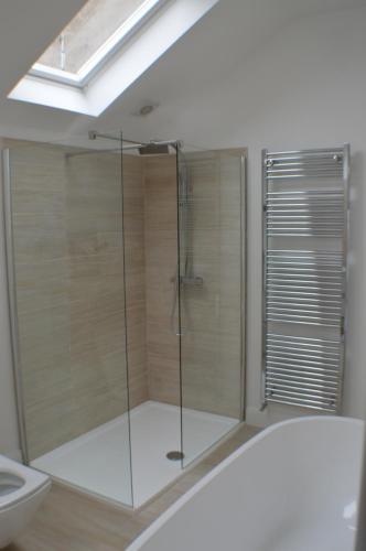 a bathroom with a glass shower with a toilet at Pier39Portrush Adult Only in Portrush