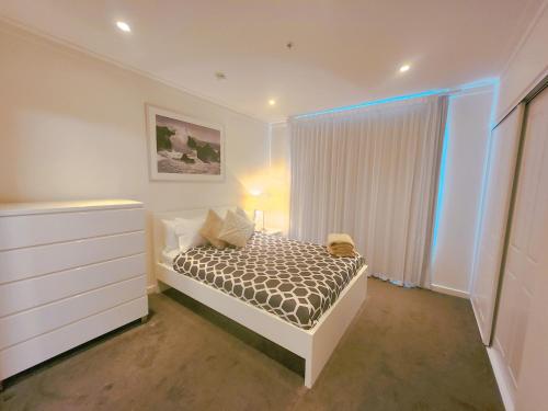 a bedroom with a bed with a dresser and a window at TAO-City of Rowlands in Adelaide