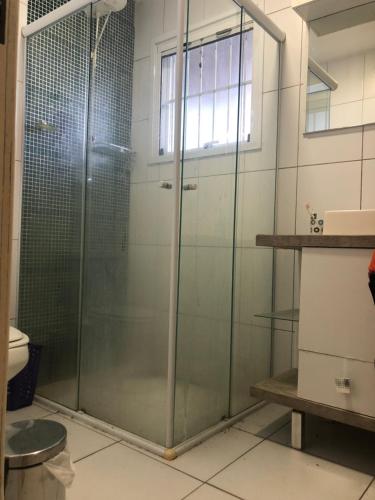 a glass shower in a bathroom with a toilet at Casa das Maria Praia do Laranjal in Pelotas