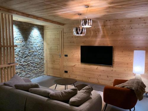 a living room with a couch and a flat screen tv at Superbe chalet avec vue montagne in Orcières