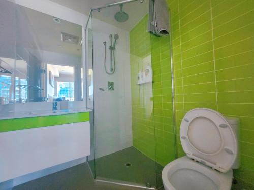 a green bathroom with a toilet and a shower at TAO-Sky of Rowlands in Adelaide