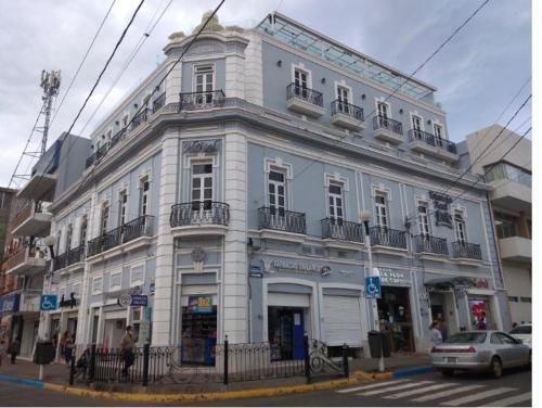 un gran edificio blanco en la esquina de una calle en Hotel Estancia Real, en Tepatitlán de Morelos