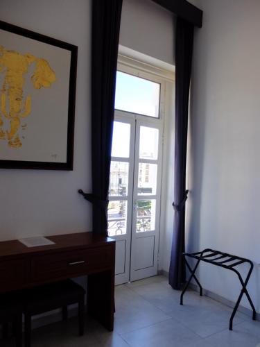 a room with a window and a desk and a door at Hotel Estancia Real in Tepatitlán de Morelos