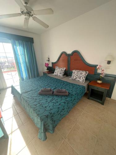 1 dormitorio con 1 cama grande y edredón azul en Sunset apartment en El Guincho