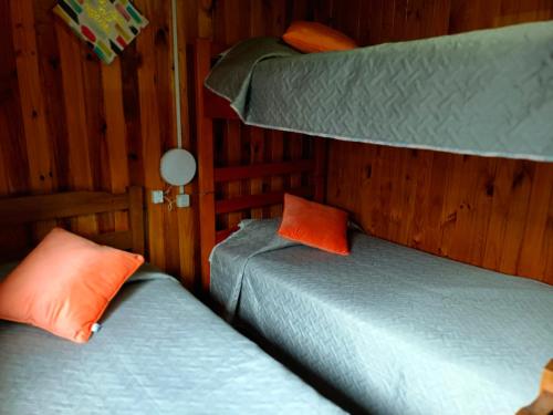 two twin beds in a room with two bunk beds at Cabañas costa maule in Constitución