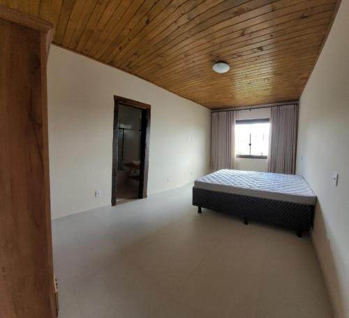 a bedroom with a bed and a wooden ceiling at Casa Alto do Campo - Lavras Novas MG in Lavras Novas