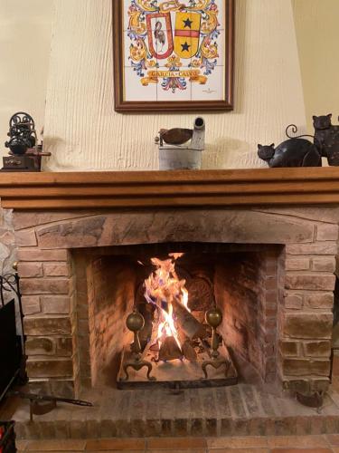 Un fuego en una chimenea de ladrillo con una imagen encima. en La casa de Serafín y Manoli, en Nestares
