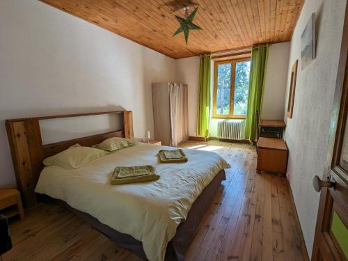 1 dormitorio con 1 cama grande y 2 toallas. en Gîte Le Chambon-sur-Lignon, 9 pièces, 15 personnes - FR-1-582-21, en Le Chambon-sur-Lignon