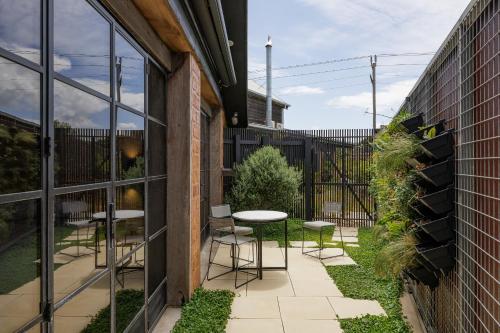 a courtyard with a table and chairs in a building at Poets corner cottage in Surf Beach