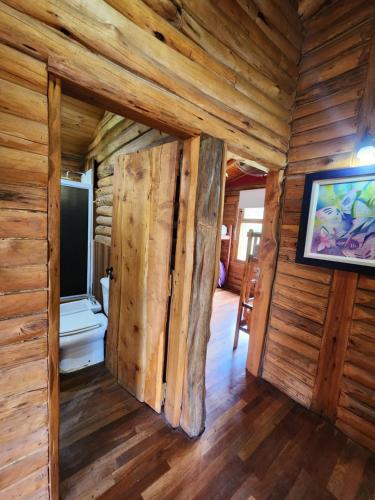 ein Zimmer in einem Blockhaus mit einer Tür in der Unterkunft Talasuas -aires de montaña in Villa General Belgrano