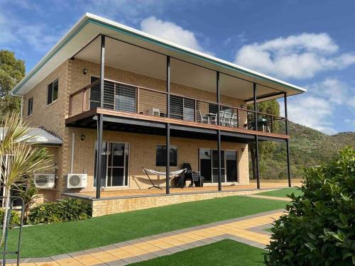 a large house with a balcony and a lawn at Nautilus @Hydeaway Bay/ Hideaway Bay in Hideaway Bay