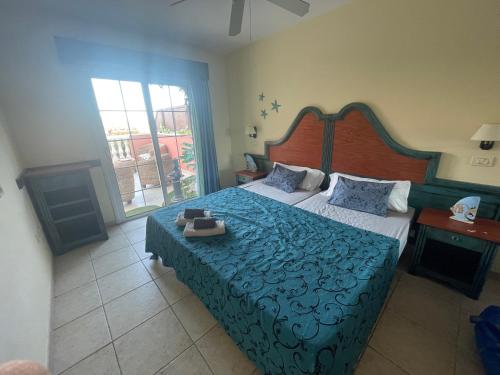 a bedroom with a large bed with a blue comforter at Sunny apartament in El Guincho
