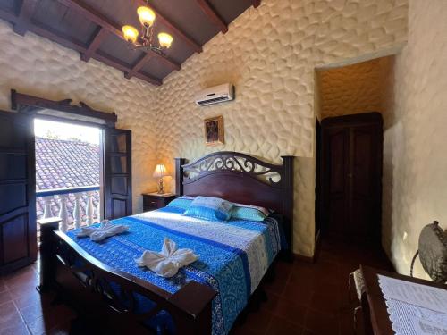 a bedroom with a bed with a blue comforter at Hotel Caxa Real in Comayagua