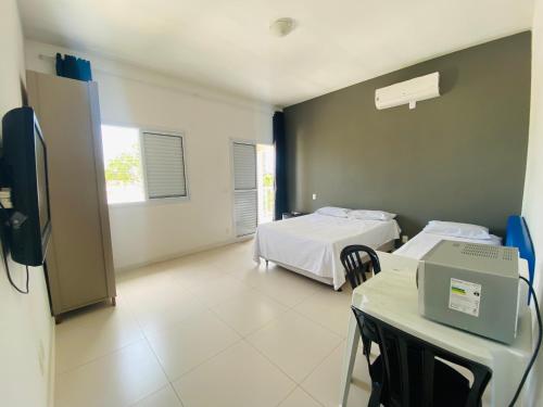 a hospital room with two beds and a table at Suíte privativa próxima ao Sesc 1 in Bertioga