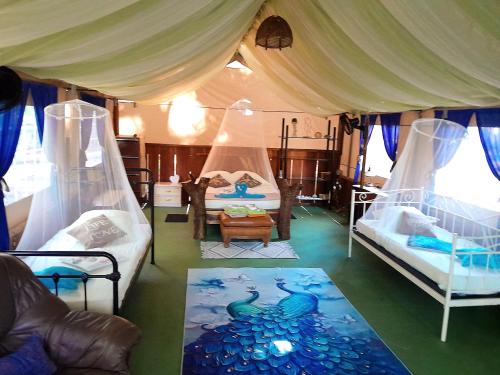 a bedroom with two beds and a room with a canopy at Fully Furnished FAMILY JUNGLE TENT, Latino Glamping Paquera in Paquera