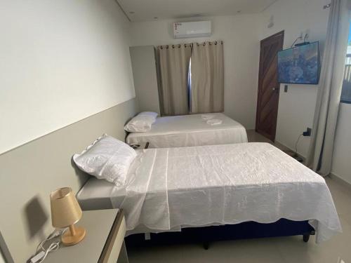 um quarto de hospital com duas camas e uma secretária em VR Flats em Maragogi