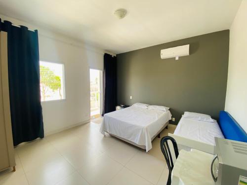ein Schlafzimmer mit zwei Betten und einem Fenster in der Unterkunft Suíte privativa próxima ao Sesc 1 in Bertioga