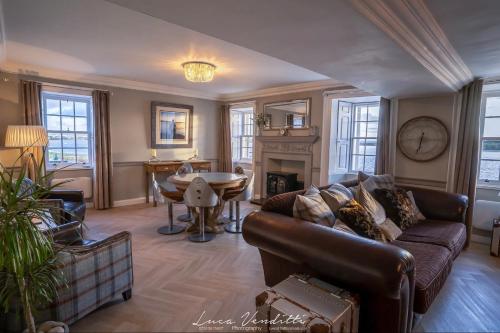 a living room with a couch and a table at Findhorn House. Luxury waterfront retreat, the perfect getaway! in Forres
