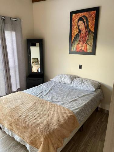 1 dormitorio con 1 cama y una pintura en la pared en Hermoso apartamento en Guatape Antioquia, en Guatapé