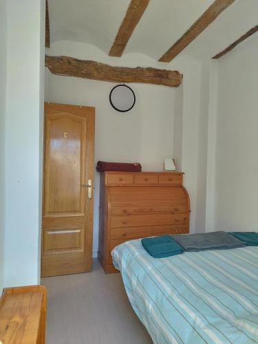 a bedroom with a bed and a wooden door at kats chulilla in Chulilla