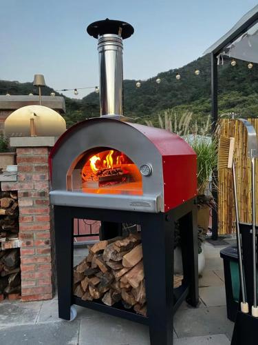 a pizza oven with a fire inside of it at Beijing MutianyuGreat Wall Let'sgo Hotel&Bar in Huairou
