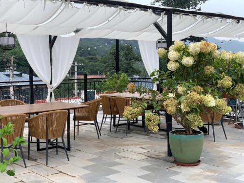 a patio with tables and chairs under a white canopy at Beijing MutianyuGreat Wall Let'sgo Hotel&Bar in Huairou