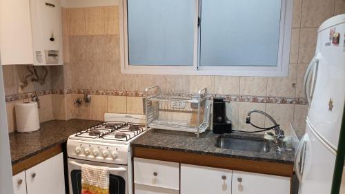 uma cozinha com um fogão branco e um lavatório em Ale Belgrano em Mar del Plata