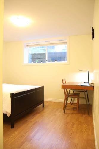 a bedroom with a bed and a desk and a window at A private suite in Port Moody in Port Moody