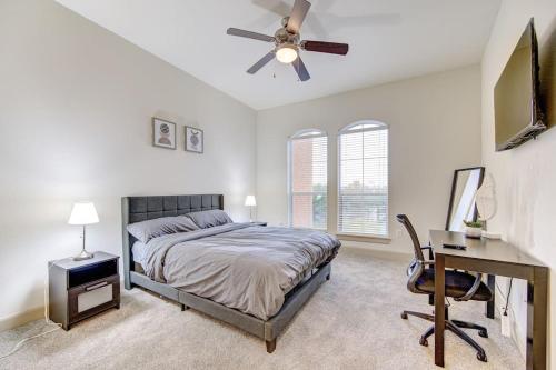 een slaapkamer met een bed, een bureau en een plafondventilator bij Chic 1Br Near NRG With Pool WiFi FreeParking in Houston