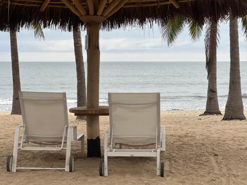 - deux chaises assises sur la plage près de l'océan dans l'établissement Maritima Playa Deluxe Ocean View Vallarta, à Nuevo Vallarta