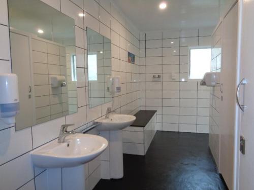 een badkamer met 2 wastafels en een grote spiegel bij Tasman Motor Camp in Tasman