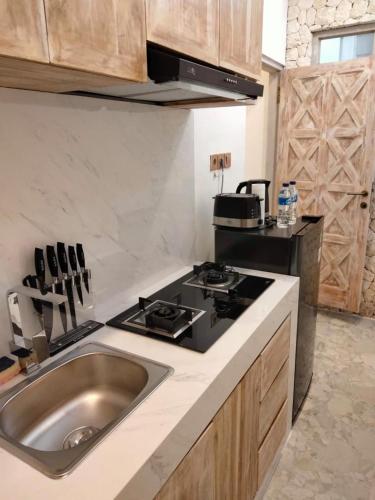 a kitchen with a sink and a stove at Puspa Ayu Villas & Apartments in Kuta