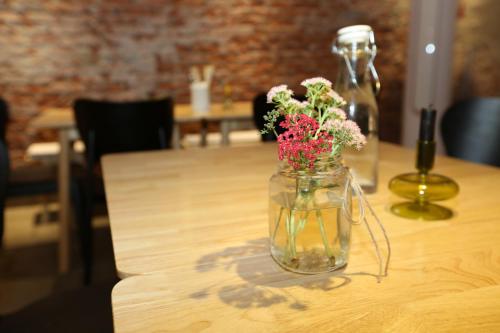 a glass jar with flowers in it on a table at Beijing MutianyuGreat Wall Let'sgo Hotel&Bar in Huairou