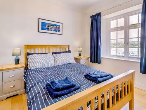 um quarto com uma cama com duas toalhas azuis em 2 Bed in Tenby 88608 em Tenby