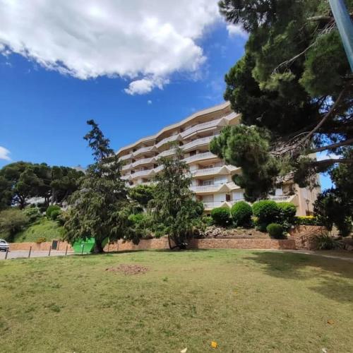 um grande edifício de apartamentos com árvores num parque em Beach, Relax & Confort em Sant Feliu de Guíxols