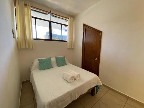 a small bedroom with a bed with towels on it at CABO BOHEMIA Tropical Garden Studios in Cabo San Lucas
