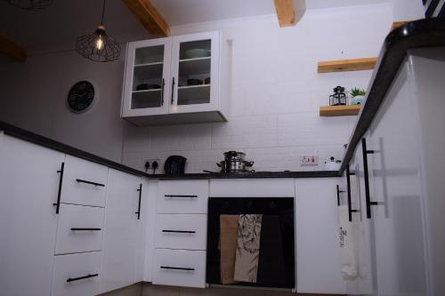 a kitchen with white cabinets and a stove top oven at Kanana Villas in Maun
