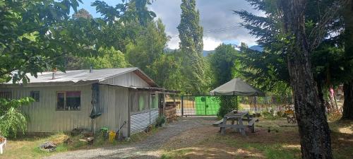 a shed with a picnic table and an umbrella at Hostal Espacio A.I.A in Minetué