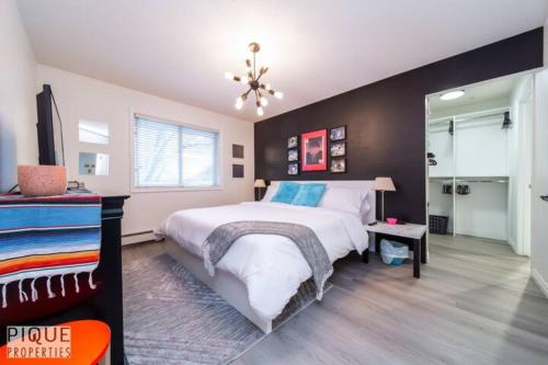 a bedroom with a large bed and a black wall at The Neon Palace - KingBed - Fireplace - Netflix - UG Park in Edmonton