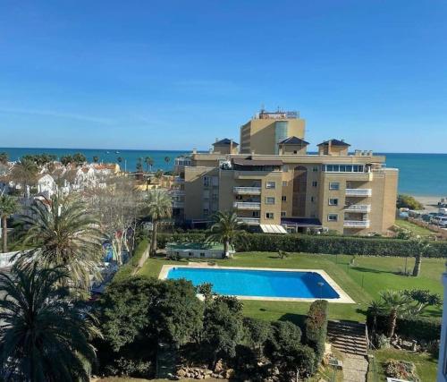 un complexe avec une piscine en face d'un bâtiment dans l'établissement Espectacular apartamento junto al mar, con piscina en Málaga, à Malaga