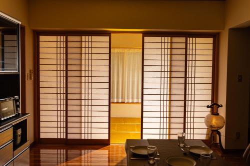 a room with three large windows with white doors at Naha Miharanosato -SEVEN Hotels and Resorts- in Naha