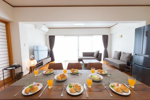 a living room with a table with plates of food at Naha Miharanosato -SEVEN Hotels and Resorts- in Naha