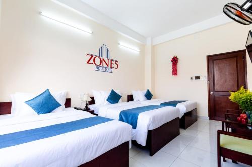 Una habitación de hotel con dos camas y un cartel en la pared. en Zone 5 Boutique Hotel, en Da Nang